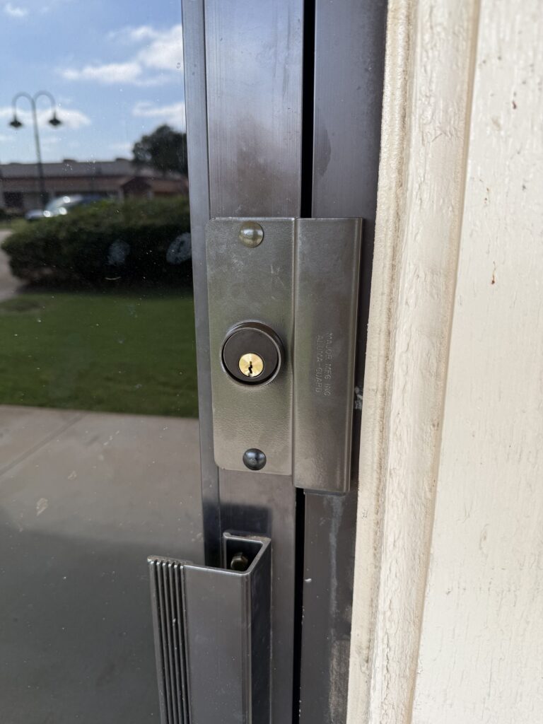 Security latch guard installed on a commercial door with an electric strike in Tulsa, Oklahoma