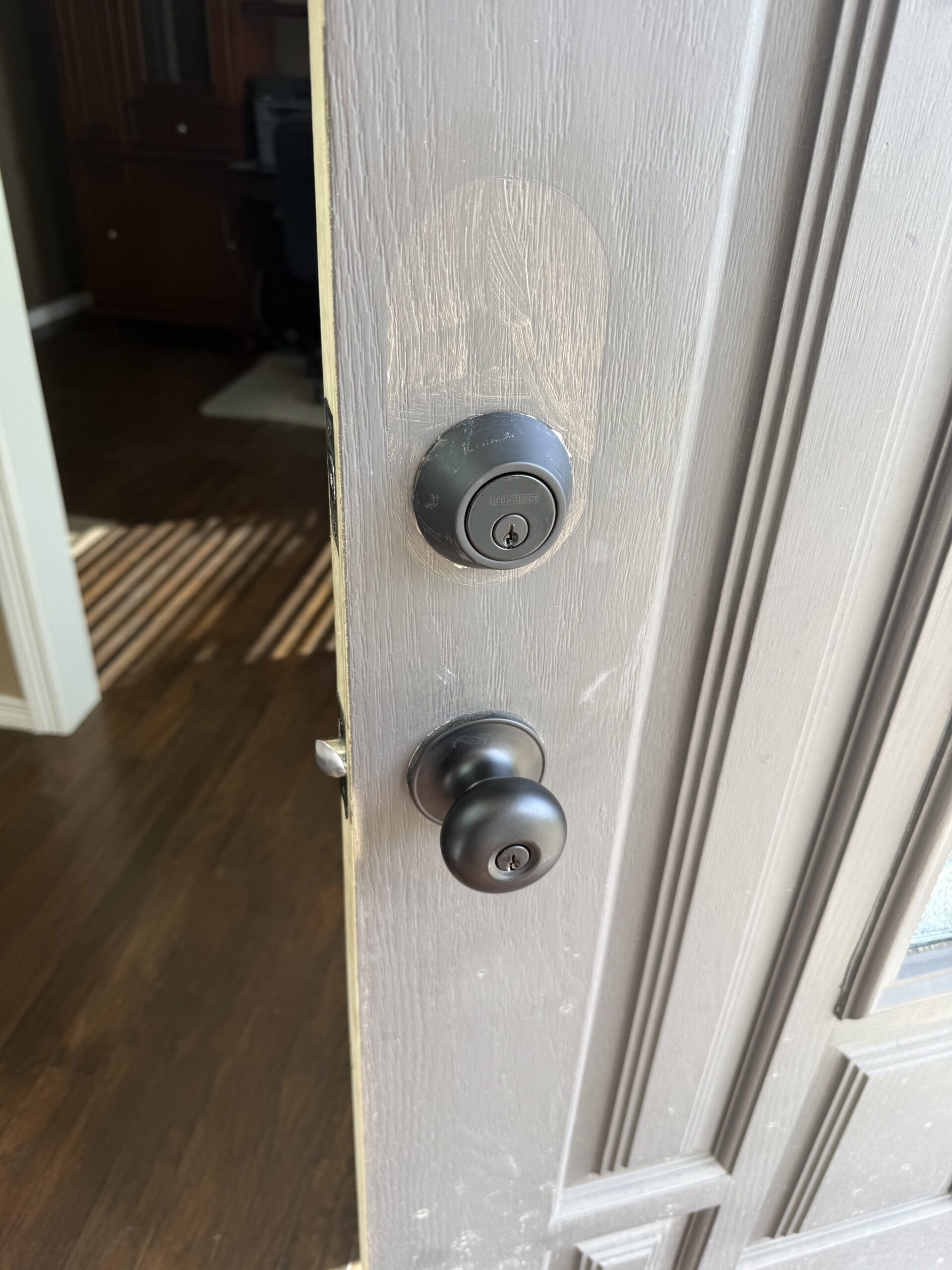 Deadbolt and doorknob on a white residential entry door