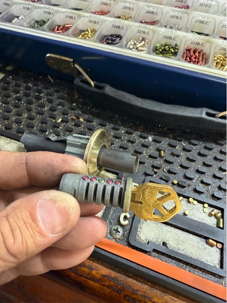 Locksmith using a lock cylinder and key machine to rekey locks after buying a house