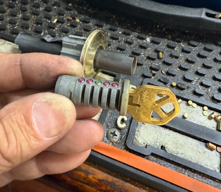 Locksmith using a lock cylinder and key machine to rekey locks after buying a house