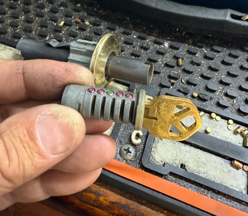 Locksmith using a lock cylinder and key machine to rekey locks after buying a house
