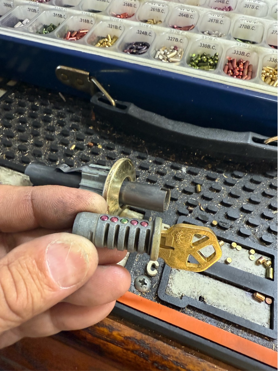 Locksmith using a lock cylinder and key machine to rekey locks after buying a house