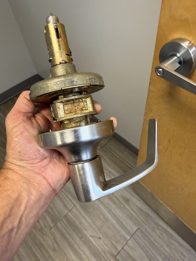 Removed bathroom lever lock showing its internal mechanism during replacement in Tulsa
