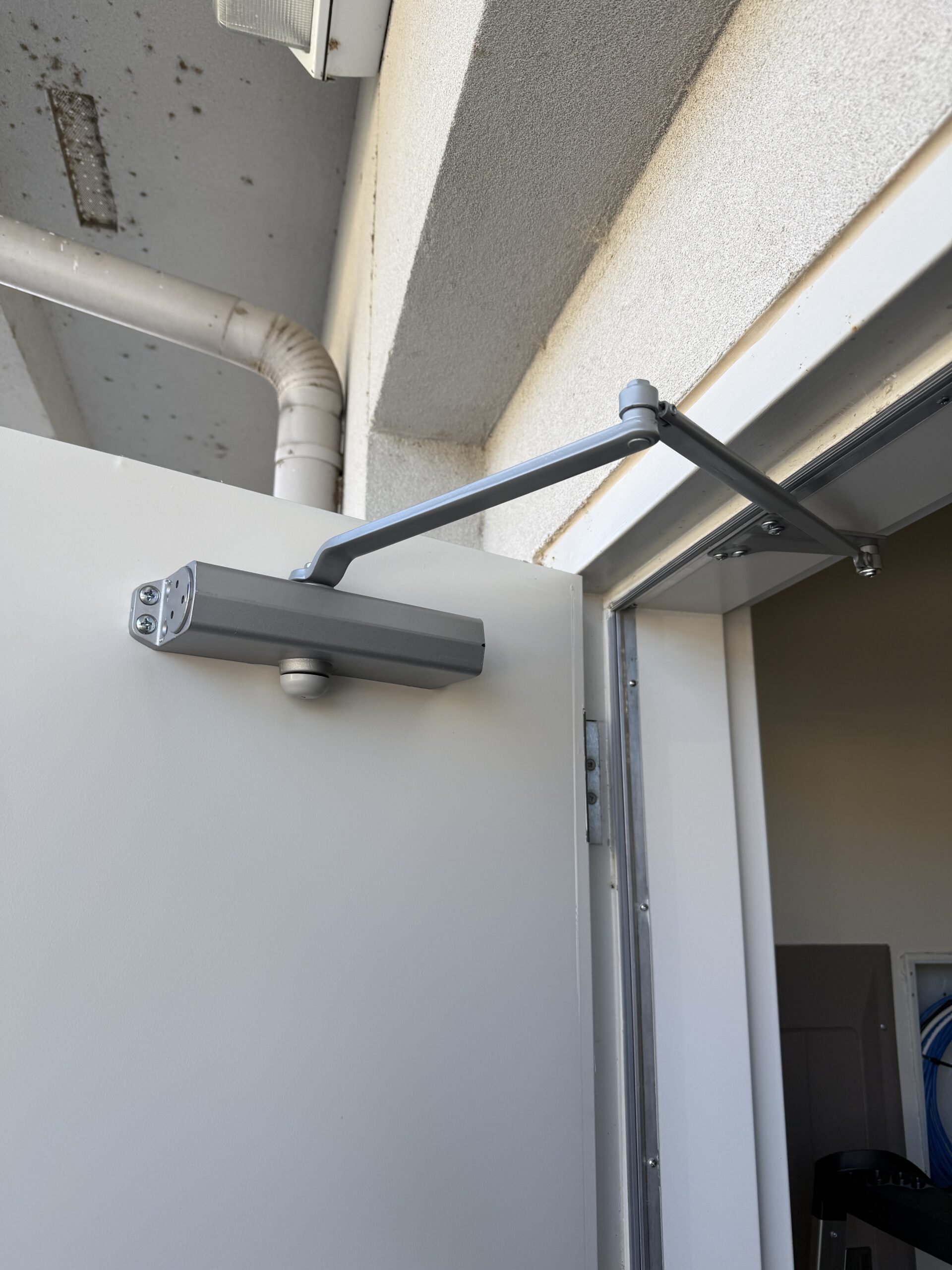 New door closer installed on a commercial suite’s back door in Bixby