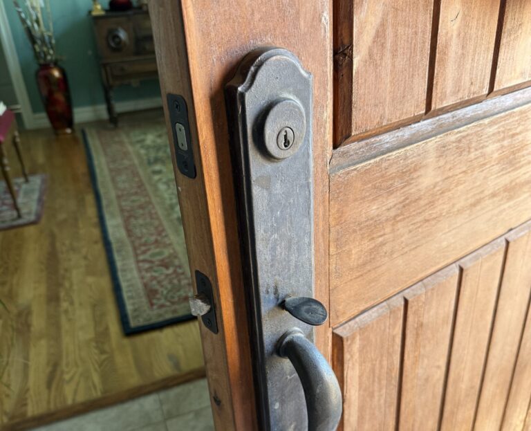 Deadbolt and handle set on a wooden front door during lock repair in Broken Arrow
