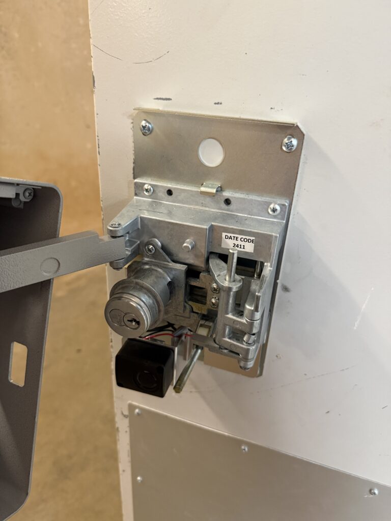 Detex exit alarm with its cover removed, showing the internal mechanism during repair in Jenks